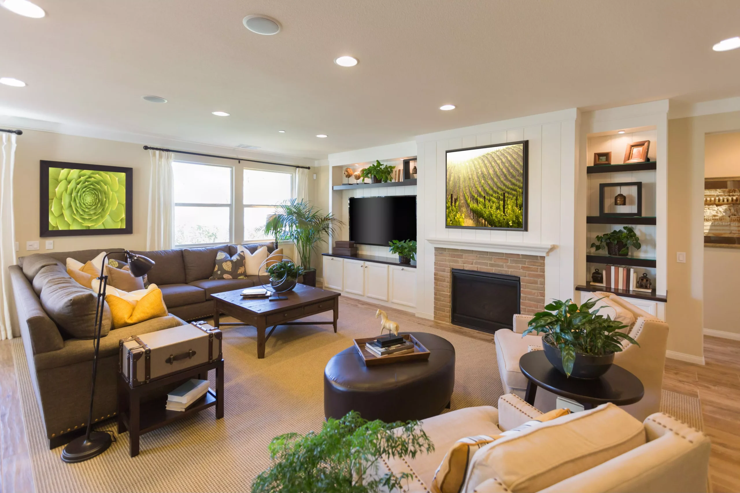 Bright, modern living room with brown sectional, yellow pillows, dark wood furniture, fireplace, TV, and potted plants. Bright, modern living room with brown sectional, yellow pillows, dark wood furniture, fireplace, TV, and potted plants.